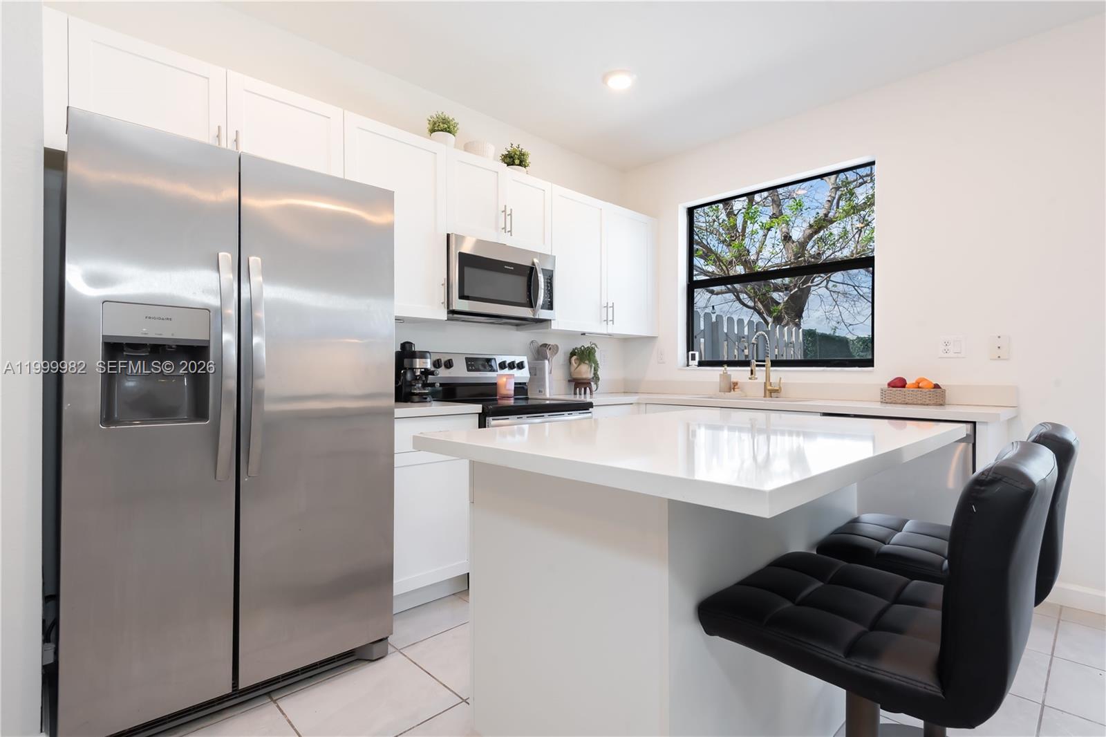 9949 Southwest 228th Terrace Miami, FL 33190 - Photo 6 of 40 a kitchen with stainless steel appliances a refrigerator and a stove top oven