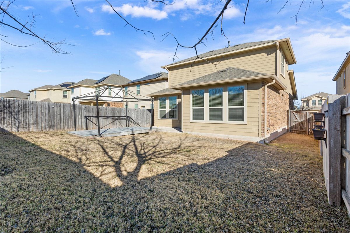 1024 Chad Loop Round Rock, TX 78665 - Photo 28 of 29 Rear view of property featuring a fenced backyard, brick siding, a gazebo, and a gate