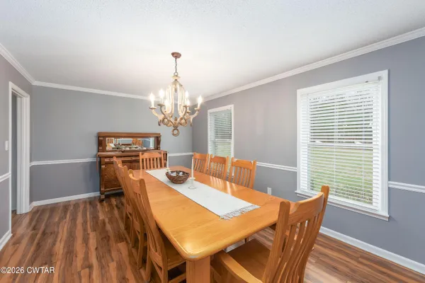 a view of a dining room with furniture a chandelier and wooden floor
