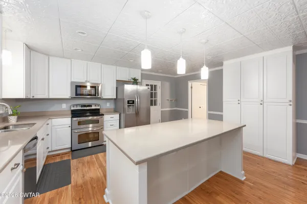 a kitchen with kitchen island a refrigerator stove microwave and cabinets