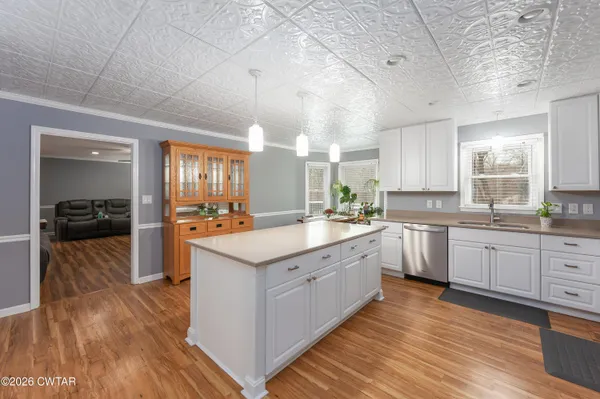 a large kitchen with cabinets wooden floor and stainless steel appliances
