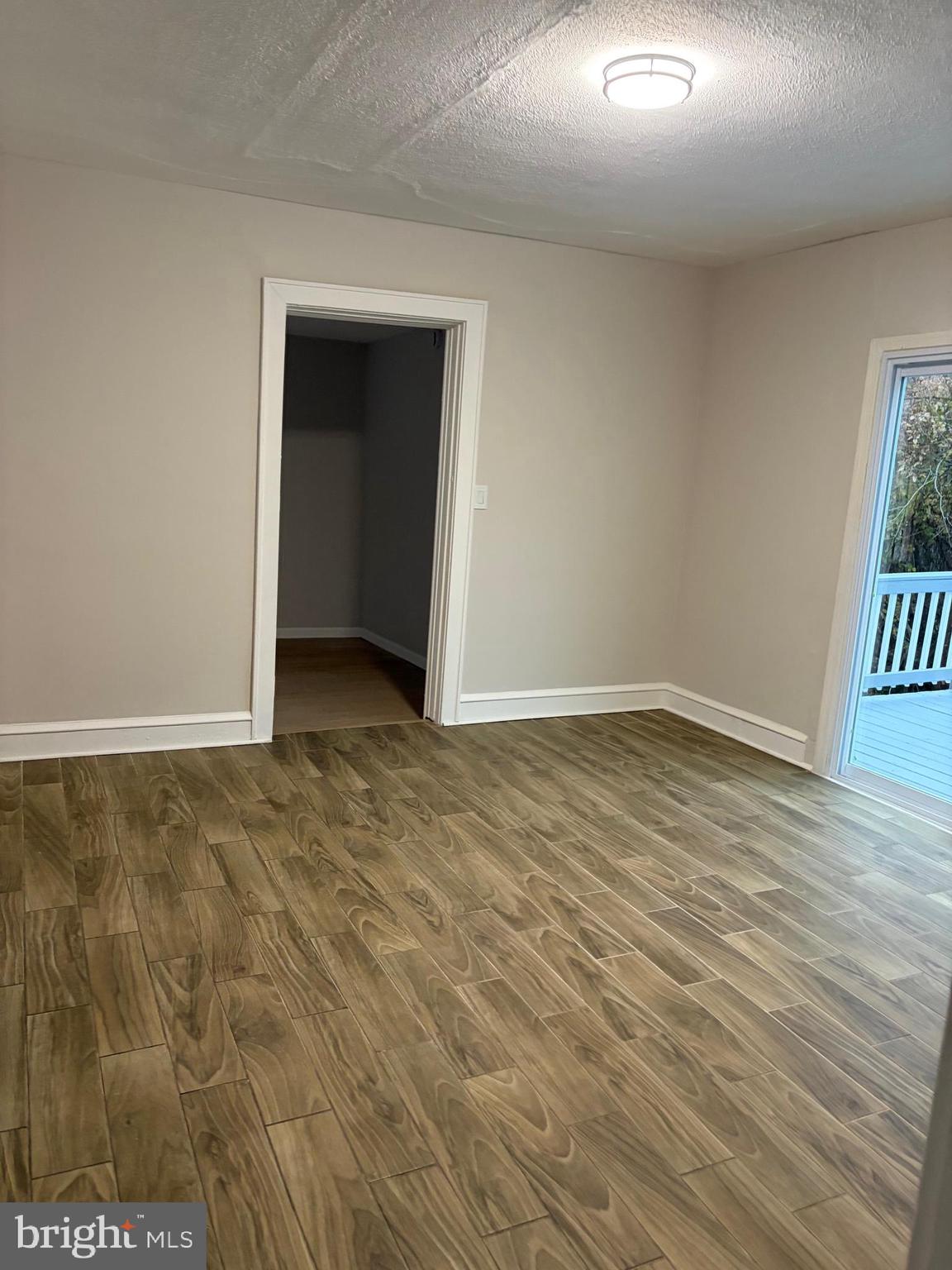 175 9th Street Salem, NJ 08079 - Photo 6 of 24 a view of an empty room with wooden floor and a window