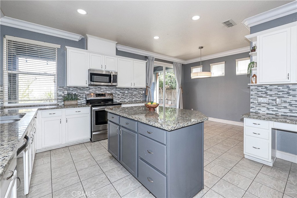 1367 Esplanade Drive Merced, CA 95348 - Photo 14 of 51 a kitchen with stainless steel appliances granite countertop a stove top oven a sink a counter top space and cabinets