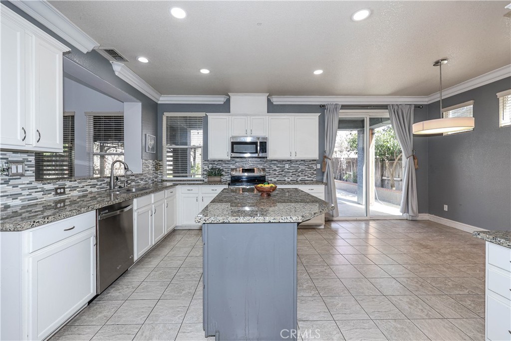 1367 Esplanade Drive Merced, CA 95348 - Photo 15 of 51 a large kitchen with granite countertop a large counter top stainless steel appliances and cabinets