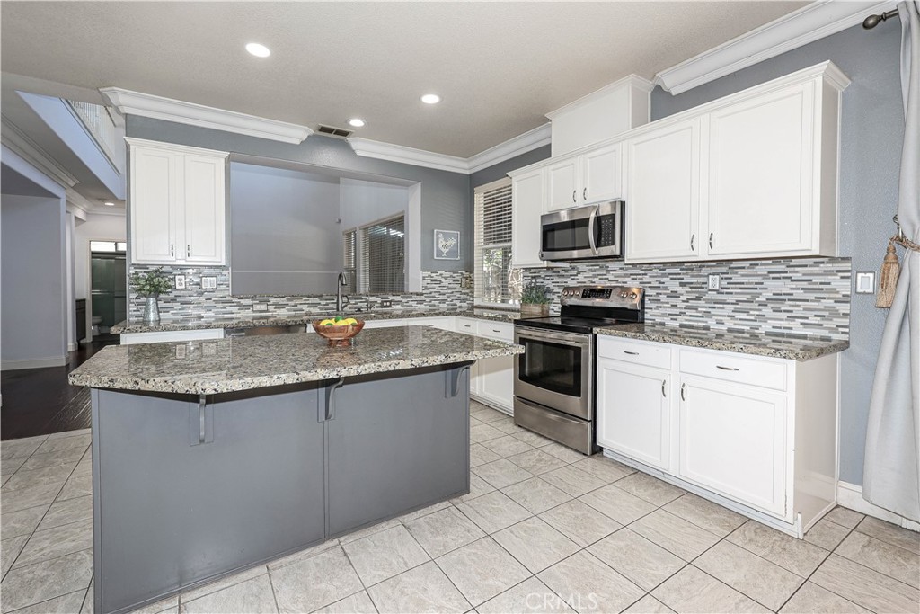1367 Esplanade Drive Merced, CA 95348 - Photo 16 of 51 a kitchen with granite countertop a sink stove and cabinets