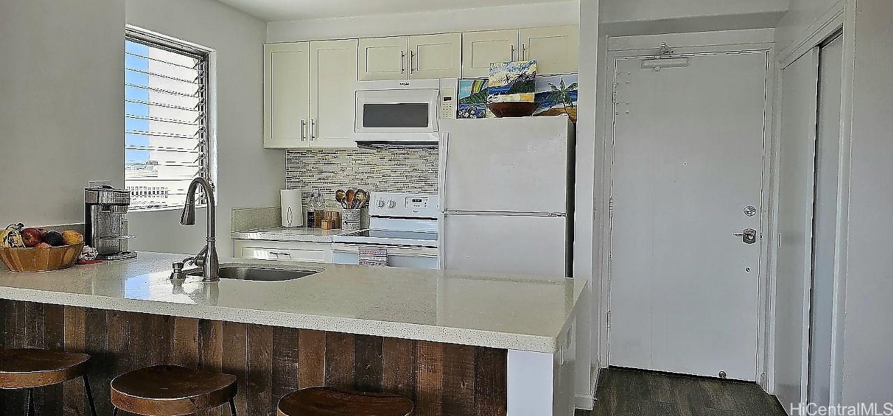 2240 Kūhiō Avenue, Unit 905 Honolulu, HI 96815 - Photo 2 of 18 a kitchen with a sink a refrigerator and cabinets