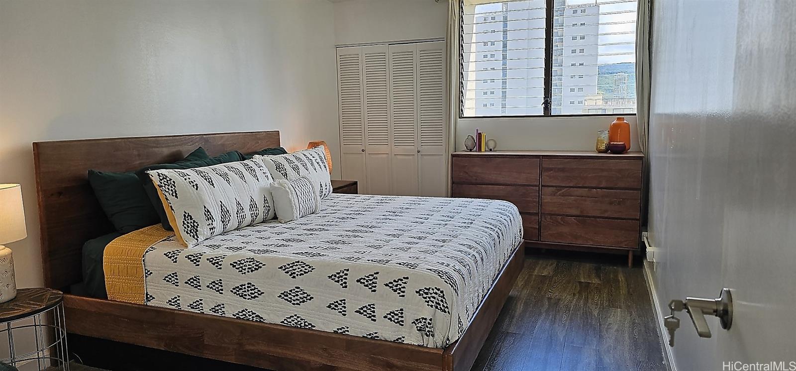 2240 Kūhiō Avenue, Unit 905 Honolulu, HI 96815 - Photo 7 of 18 a bedroom with a bed and wooden floor