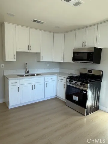 a kitchen with stainless steel appliances granite countertop a stove a sink and a microwave