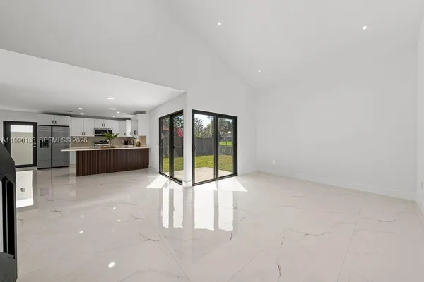 a view of kitchen with refrigerator and window