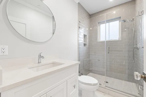 a bathroom with a sink a toilet and a mirror