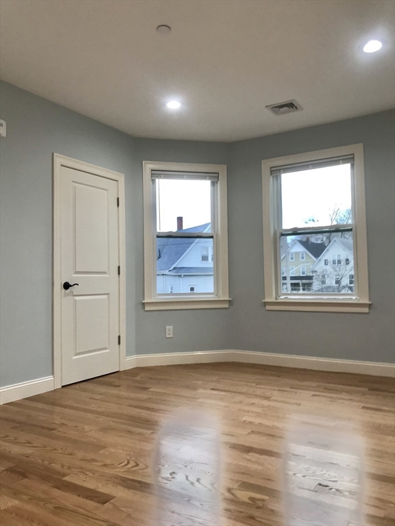 16 Grove Street, Unit 3 Malden, MA 02148 - Photo 3 of 6 a view of an empty room with wooden floor and a window