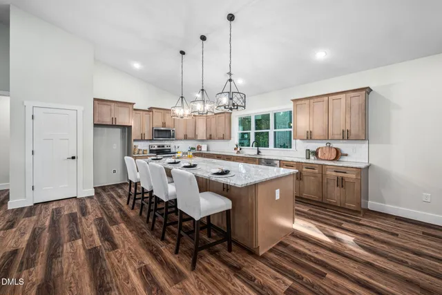 a view of a dining room with furniture wooden floor and a kitchen view