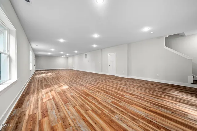 a view of a room with wooden floor and white walls