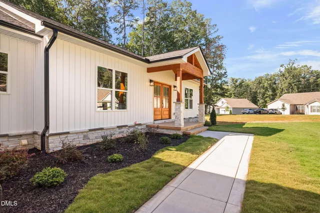a aerial view of a house with swimming pool and large trees