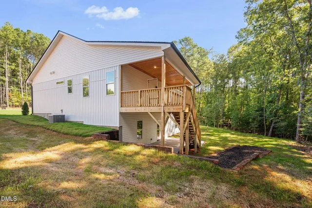 a view of a house with backyard and trees
