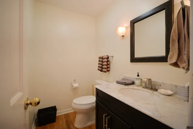 a bathroom with a granite countertop sink mirror and toilet