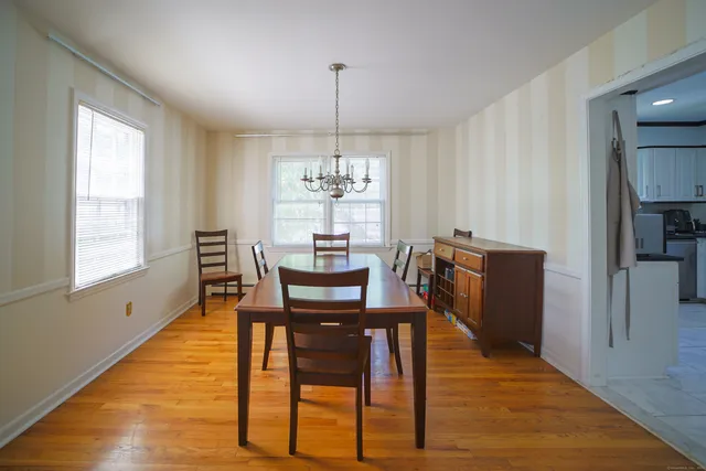 a dining room with furniture a chandelier and wooden floor