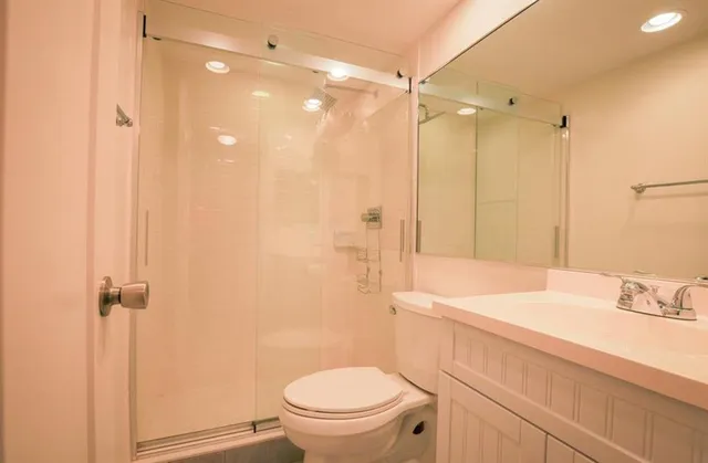 a bathroom with a sink a toilet and shower