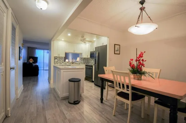 a dining room with wooden floor a chandelier a wooden table and chairs