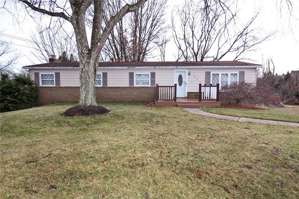 a view of a yard in front of a house with large tree