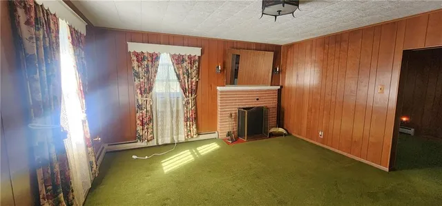 a view of an empty room with a fireplace and a window