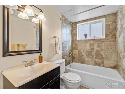 a bathroom with a sink mirror vanity bathtub and a toilet