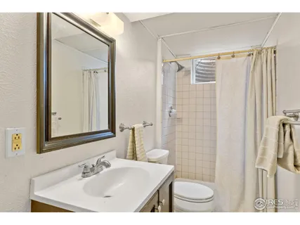 a bathroom with a sink a toilet a mirror and shower