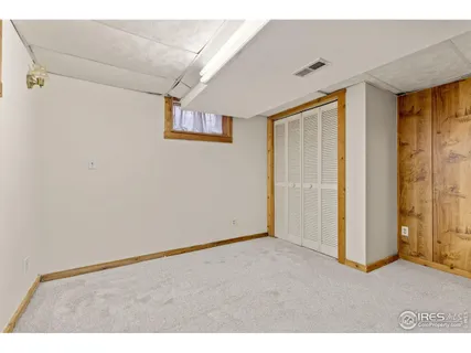 a view of an empty room with closet and a window