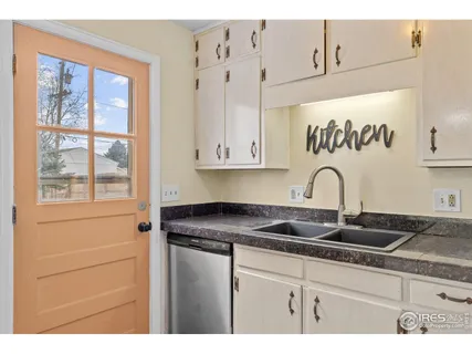 a kitchen with granite countertop white cabinets and window