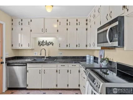 a kitchen with granite countertop a stove sink and cabinets