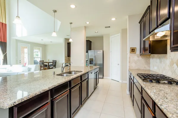 a kitchen with stainless steel appliances granite countertop a sink a stove and a refrigerator