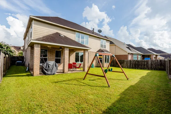 a view of a house with swimming pool and a yard