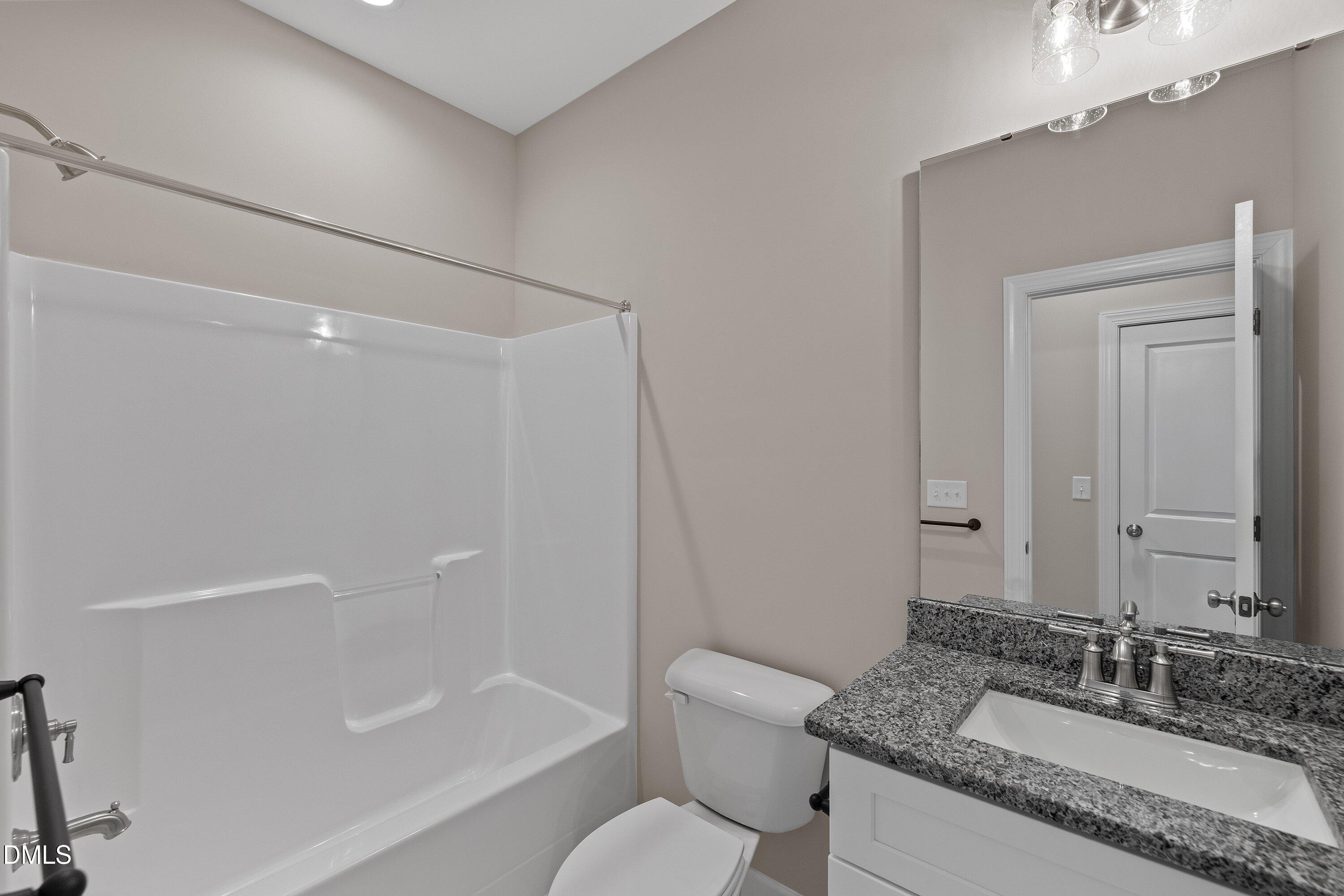 926 Micro Road West Selma, NC 27576 - Photo 37 of 41 a bathroom with a granite countertop sink a toilet and shower
