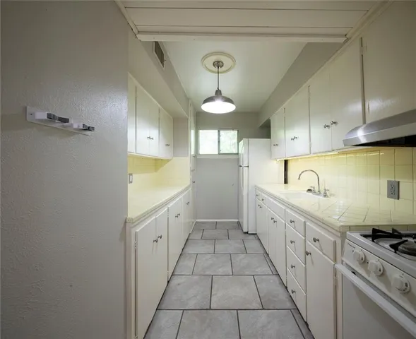 a kitchen with cabinets a sink and appliances