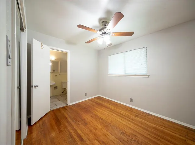 an empty room with closet and fan