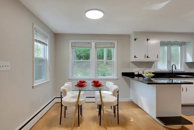 a kitchen with stainless steel appliances granite countertop a stove a sink a dining table and chairs