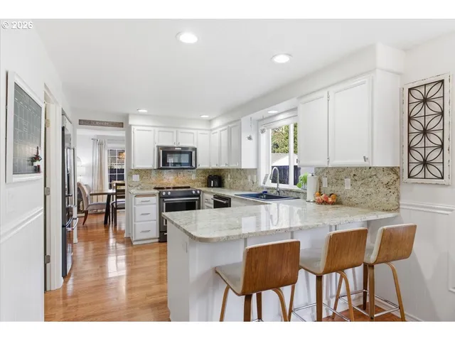 a kitchen with cabinets a sink and chairs