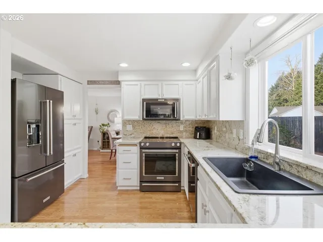 a kitchen with granite countertop a sink stove and refrigerator