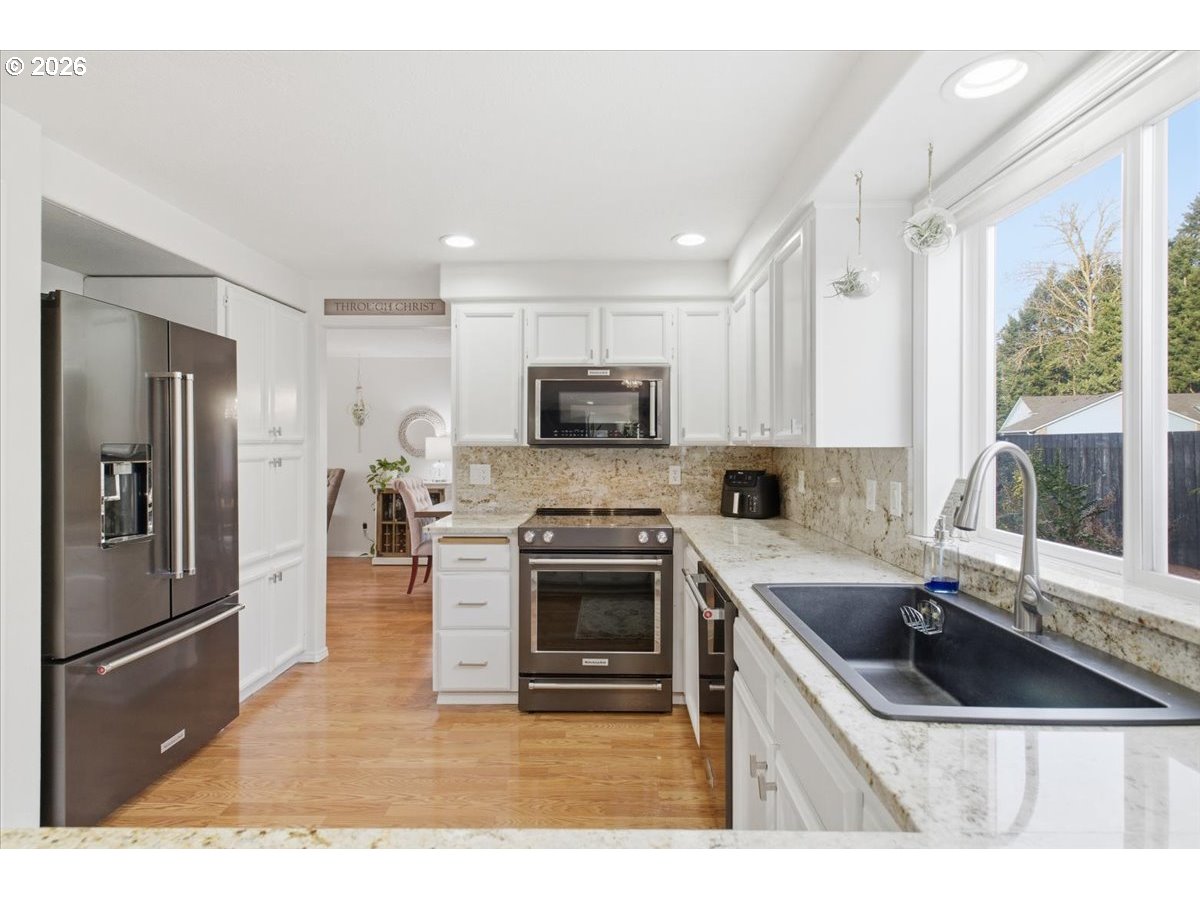 229 Hazelbrook Drive North Keizer, OR 97303 - Photo 18 of 48 a kitchen with granite countertop a sink stove and refrigerator