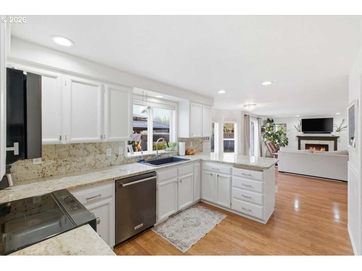 229 Hazelbrook Drive North Keizer, OR 97303 - Photo 19 of 48 a large white kitchen with a sink and dishwasher a stove top oven with wooden floor