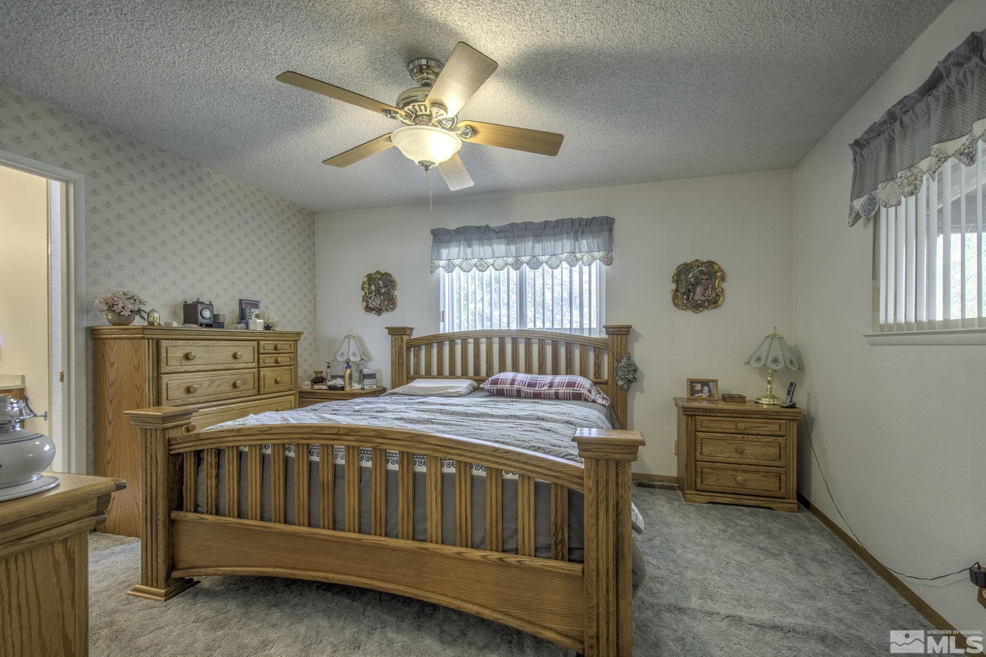 2626 Rice Road Fallon, NV 89406 - Photo 20 of 39 a bedroom with a bed and a chandelier
