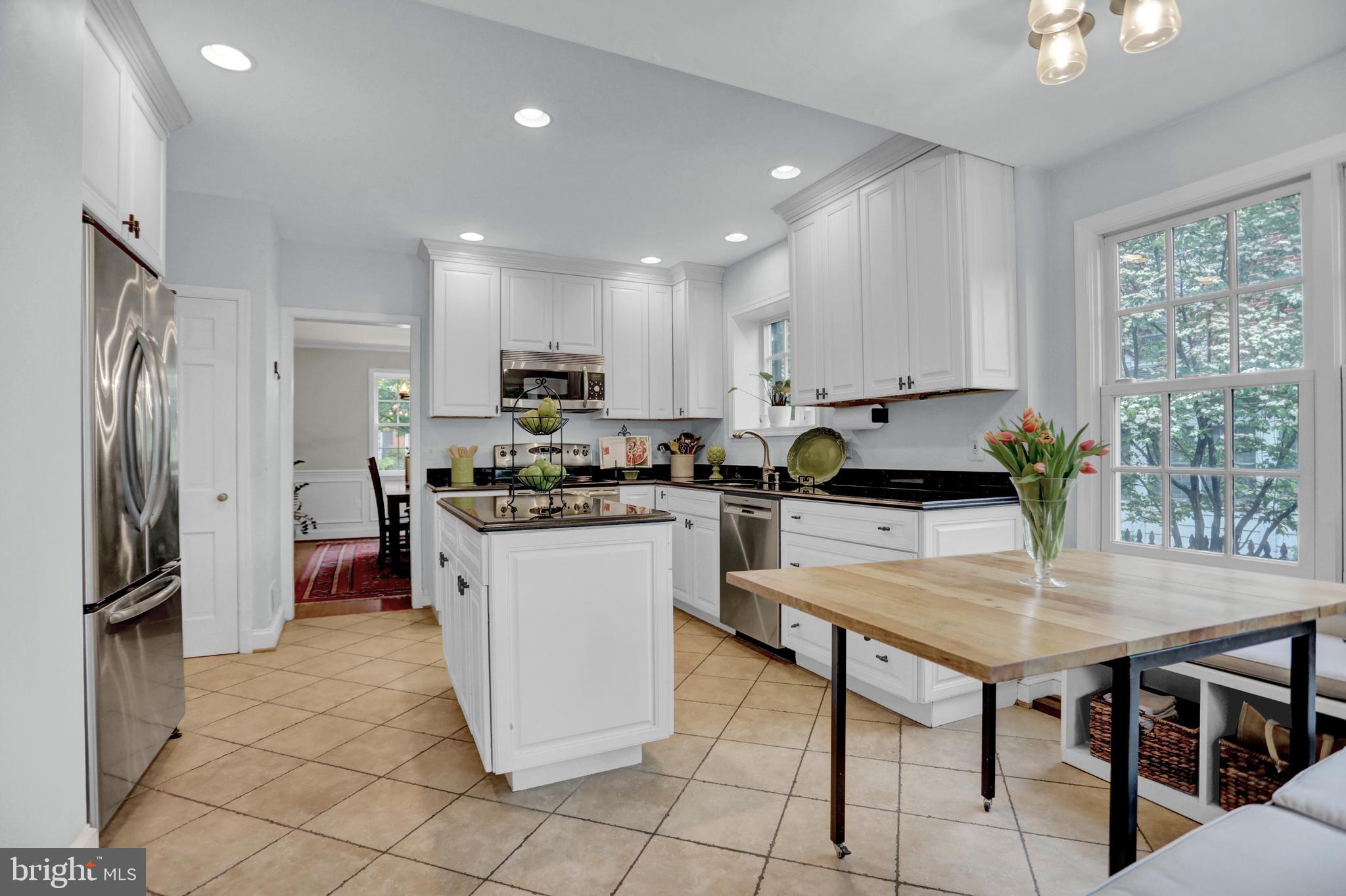 121 Croydon Road Baltimore, MD 21212 - Photo 9 of 57 a kitchen with a refrigerator a stove a sink a dining table and chairs