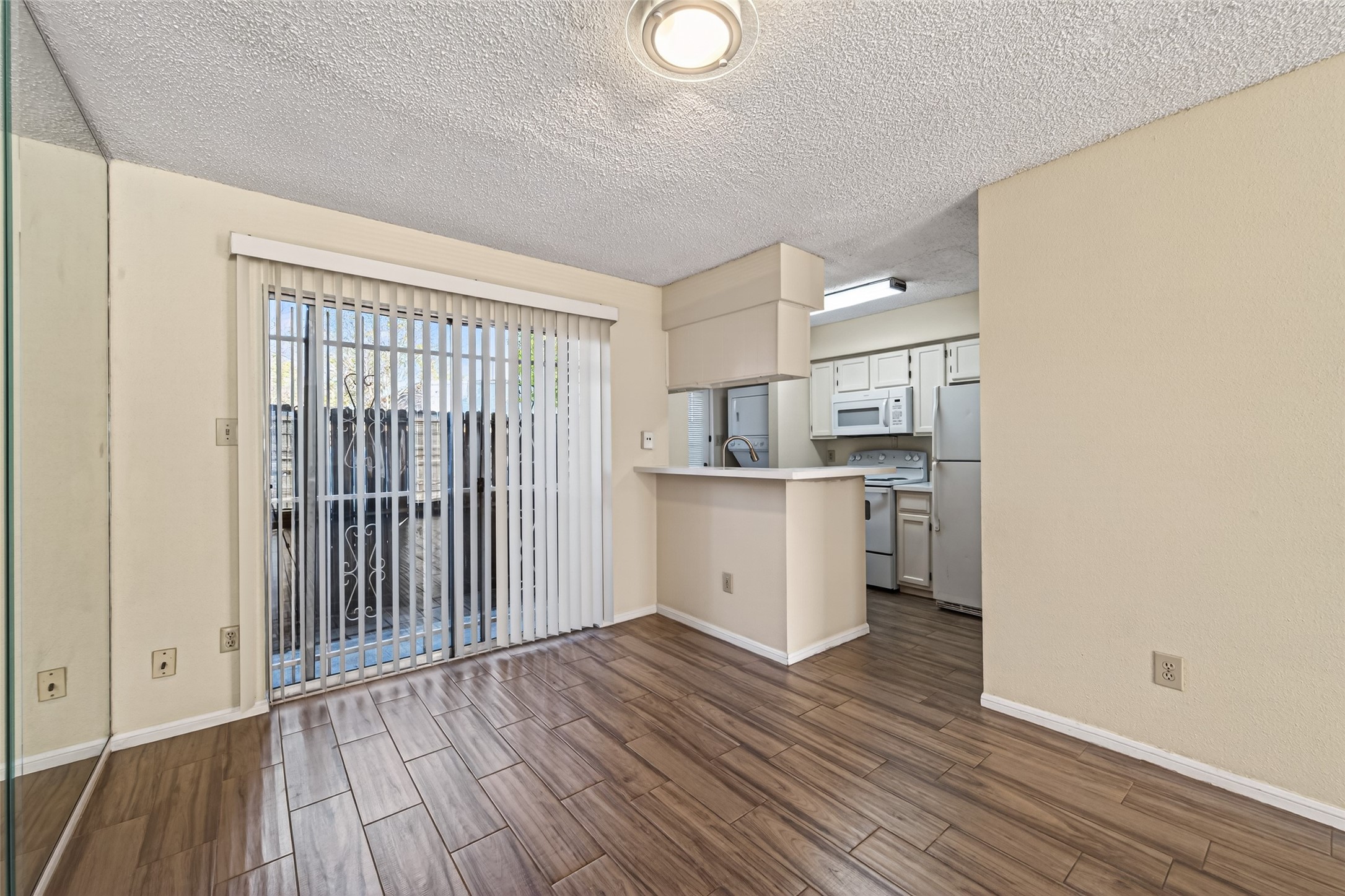 3100 Jeanetta Street, Unit 1004 Houston, TX 77063 - Photo 12 of 42 Positioned right by the sliding glass doors, this dining space features a convenient pass-through to the kitchen for easy serving and conversation.