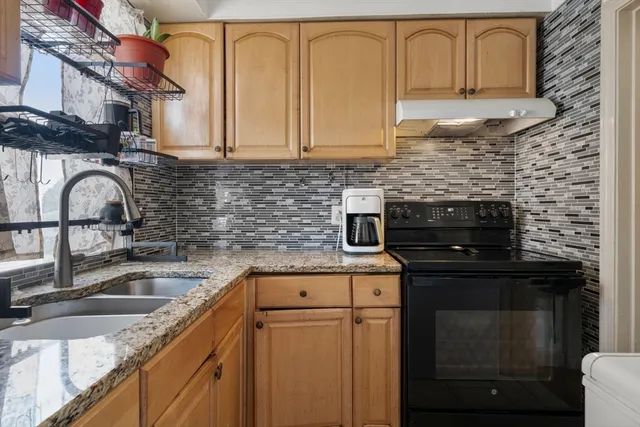 a kitchen with stainless steel appliances granite countertop a sink stove and cabinets