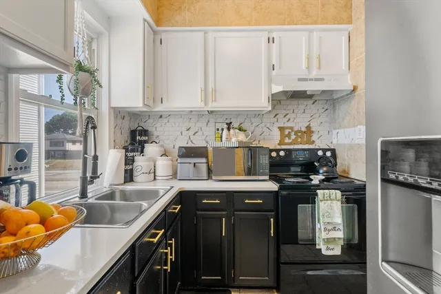 a kitchen with stainless steel appliances granite countertop a sink a stove and a cabinets