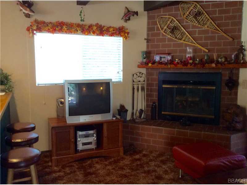 168 Riverside Avenue Sugarloaf, CA 92386 - Photo 7 of 23 a living room with furniture a flat screen tv and a fireplace