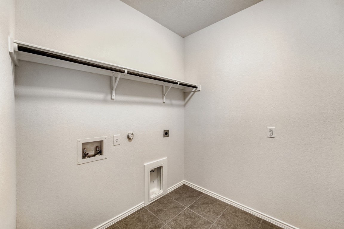 433 Druse Lane Jarrell, TX 76537 - Photo 25 of 28 Laundry area with gas dryer hookup, hookup for an electric dryer, washer hookup, and dark tile patterned floors