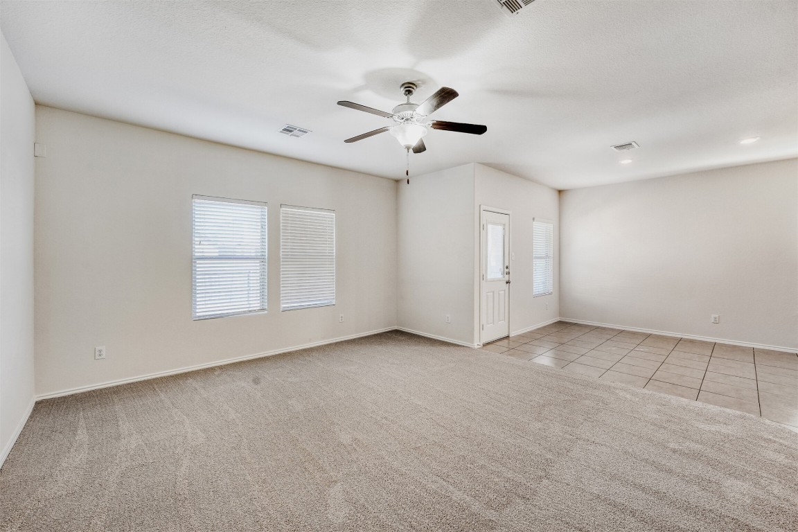 433 Druse Lane Jarrell, TX 76537 - Photo 6 of 28 Empty room with light colored carpet, ceiling fan, and light tile patterned floors