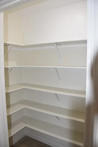 a view of walk in closet with empty racks