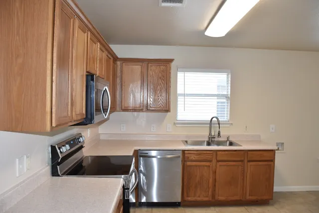 a kitchen with stainless steel appliances a sink stove and cabinets